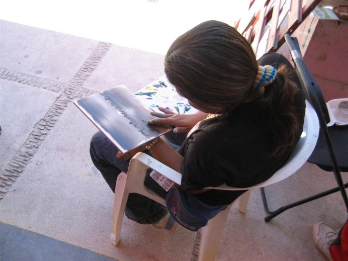 Closeup of the woman painting with fingers and fingernails