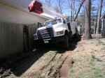 Backing the truck in wasn't a whole lot more successful but they were able to winch it further in.  Notice the angle of the truck.  It is about 3-4 feet from the house and the air conditioning compressor on muddy ground and a slope.