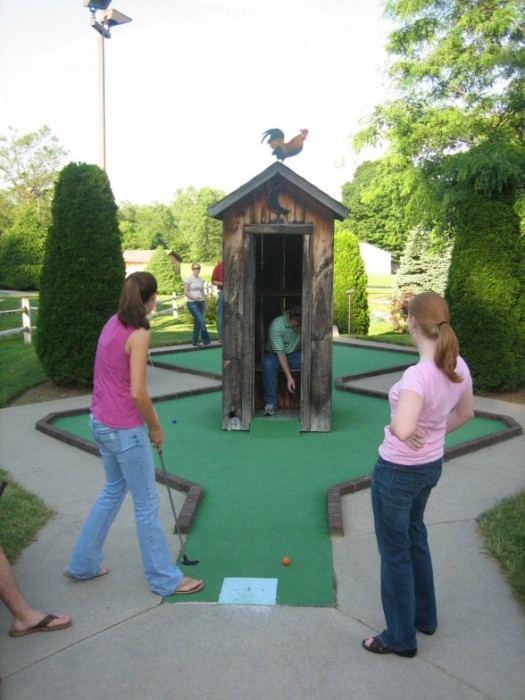 Cate and Emily taking turns hitting the ball into the outhouse (very fast and hard) in turn, hitting Brian :-)